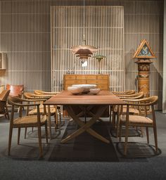 a wooden table surrounded by chairs and lamps