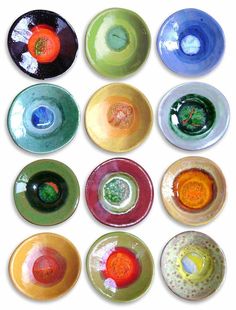 nine different colored glass bowls sitting on top of each other