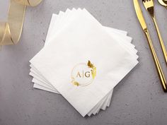 four napkins with gold foil on them sitting next to a fork, knife and spoon