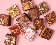 there are many different types of chocolates on the pink surface, including brownies