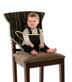 a baby sitting on top of a wooden chair with a black and green seat cover