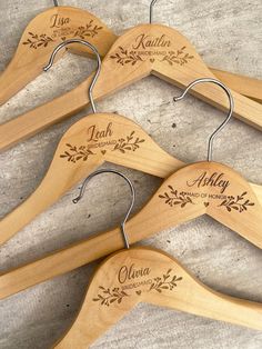 three wooden hangers with personalized names on them, hanging from concrete flooring