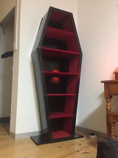 a large black and red book shelf next to a chair