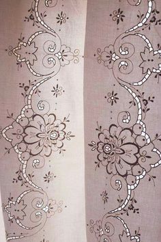 an embroidered curtain with flowers and vines on it