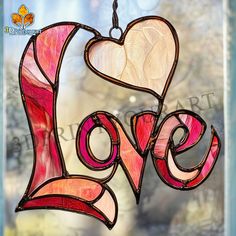 a stained glass window with the word love hanging from it