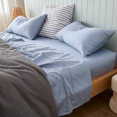 a bed with blue sheets and pillows on it