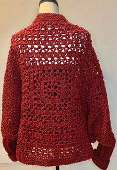 a red crocheted sweater on a mannequin