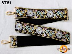 two lanyards with flowers on black and gold trimming, one has a metal hook