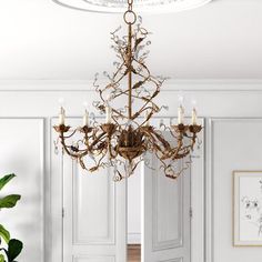 a chandelier hanging from the ceiling in a room with white walls and doors