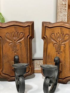 two wooden wall sconces with metal handles on display in front of a mirror