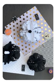 three black and white hair clips on top of a polka doted paper with gold dots