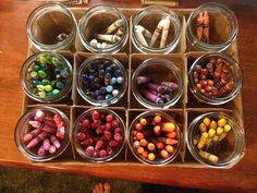 a wooden table topped with containers filled with crayons