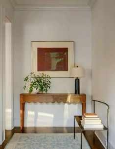 a living room with a rug, table and plant on the side walk in front of it