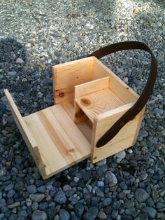 a wooden box sitting on top of a gravel covered ground