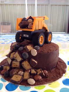 a birthday cake made to look like a dump truck on top of some wood chips