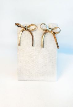 Elevate any outfit with our Bows & Kisses Earrings. These chic earrings feature a beautiful gold snake chain design, with playful bow accents that add a touch of sophistication. The perfect addition to your jewelry collection, these earrings are sure to make a statement. Post back Approximately 1.25" in length