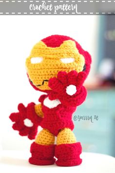 a crocheted iron man doll sitting on top of a white table next to a window