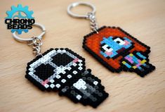 two pixel keychains that have been made to look like video games characters