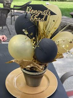 an arrangement of balloons and confetti in a vase on top of a table