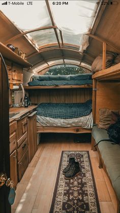 the inside of a small camper with bunk beds and rugs on the floor