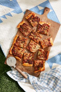 pizza cut into squares on a cutting board