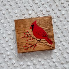 a red bird sitting on top of a wooden box