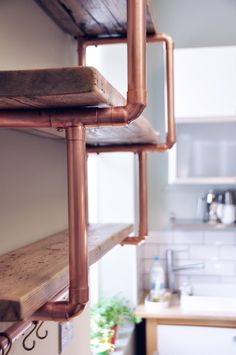 copper pipes hang from the ceiling in a kitchen