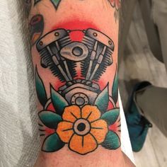 a close up of a person's arm with a motorcycle engine tattoo on it