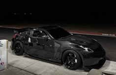 a black sports car parked next to a parking meter