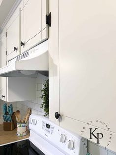 a white stove top oven sitting inside of a kitchen next to wooden counter tops and cabinets