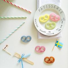 a plate with donuts and pins on it sitting next to some paper straws