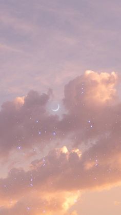 the sky is filled with stars and clouds as the moon shines in the distance