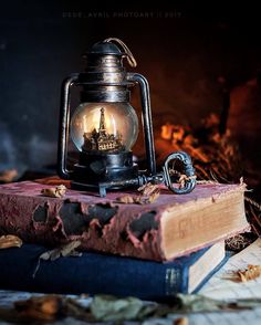 an old fashioned lantern sitting on top of two books