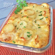 a casserole dish with potatoes and parsley in it on an orange place mat