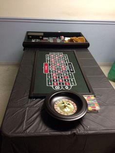 a black table topped with a casino rouleet and a clock on top of it