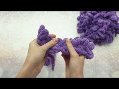 someone is crocheting purple yarn with their hands