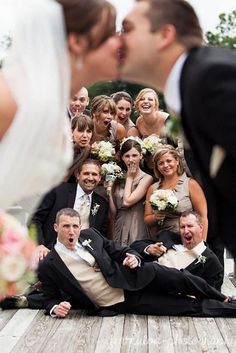 a group of people that are posing for a picture together in front of a bride and groom