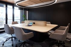 an empty conference room with chairs and a laptop on the table