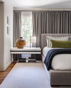 a bedroom with a bed, nightstand and window