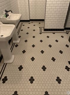 two white sinks sitting next to each other on a bathroom floor with black and white tile