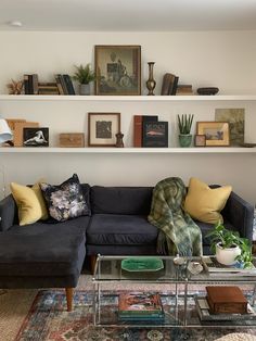 a living room filled with furniture and lots of books on the shelf above it's head