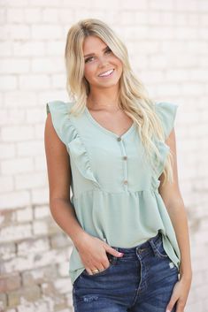 Nothing says "Hi, summer," quite like an airy top. This one's complete with smocked detailing, a v neckline and flutter sleeves. Our Jenna Ruffle Top is perfect with jeans or cut offs. Models are 5'7" and 5'8" wearing a size small Length of a small is 24" 100% Polyester Breezy Summer Blouse With Ruffles, Summer Breezy Blouse With Ruffles, Casual Butterfly Sleeve Blouse For Summer, Breezy V-neck Summer Top, Trendy Summer Blouse With Flutter Sleeves, Breezy V-neck Top For Day Out, Flowy Summer Tops With Butterfly Sleeves, Flowy Summer Top With Ruffle Sleeves, Bohemian Ruffle Sleeve Tops For Summer