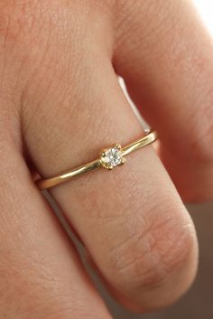 a woman's hand with a diamond ring on her left finger, showing the side view