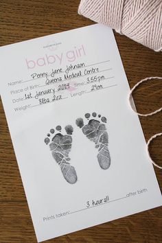 a baby's hand and foot print on a white paper with twine next to it