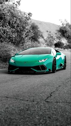 a green sports car parked on the side of a road