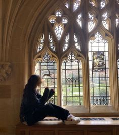 a woman sitting on top of a window sill