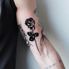 a man with a rose tattoo on his arm