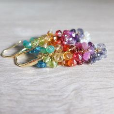 These  are Multi Gemstone Colorful Rainbow Earrings Wire Wrapped in Gold Filled, Gorgeous rainbow earrings feature an array of sparkling gemstones cascading down gold filled chain  This pair of sparkling earrings have the colors of the rainbow - red, orange green, yellow  , blue, Purple, Pink and These  colors make them really beautiful They are finished with  gold filled teardrop hook The gemstone are all natural and they are : Moonstone, ,Raw ruby, pink sapphire, Orange Carnelian, Yellow Citri Sparkling Earrings, Raw Ruby, Costume Jewelery, Ombre Earrings, Orange Carnelian, Violet Rose, Green Yellow Blue, Earrings Wire, Bleu Violet