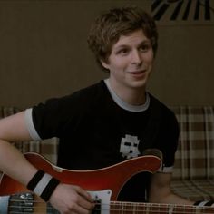 a young man is playing an electric guitar