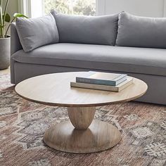 a living room with a couch, coffee table and books on the top of it